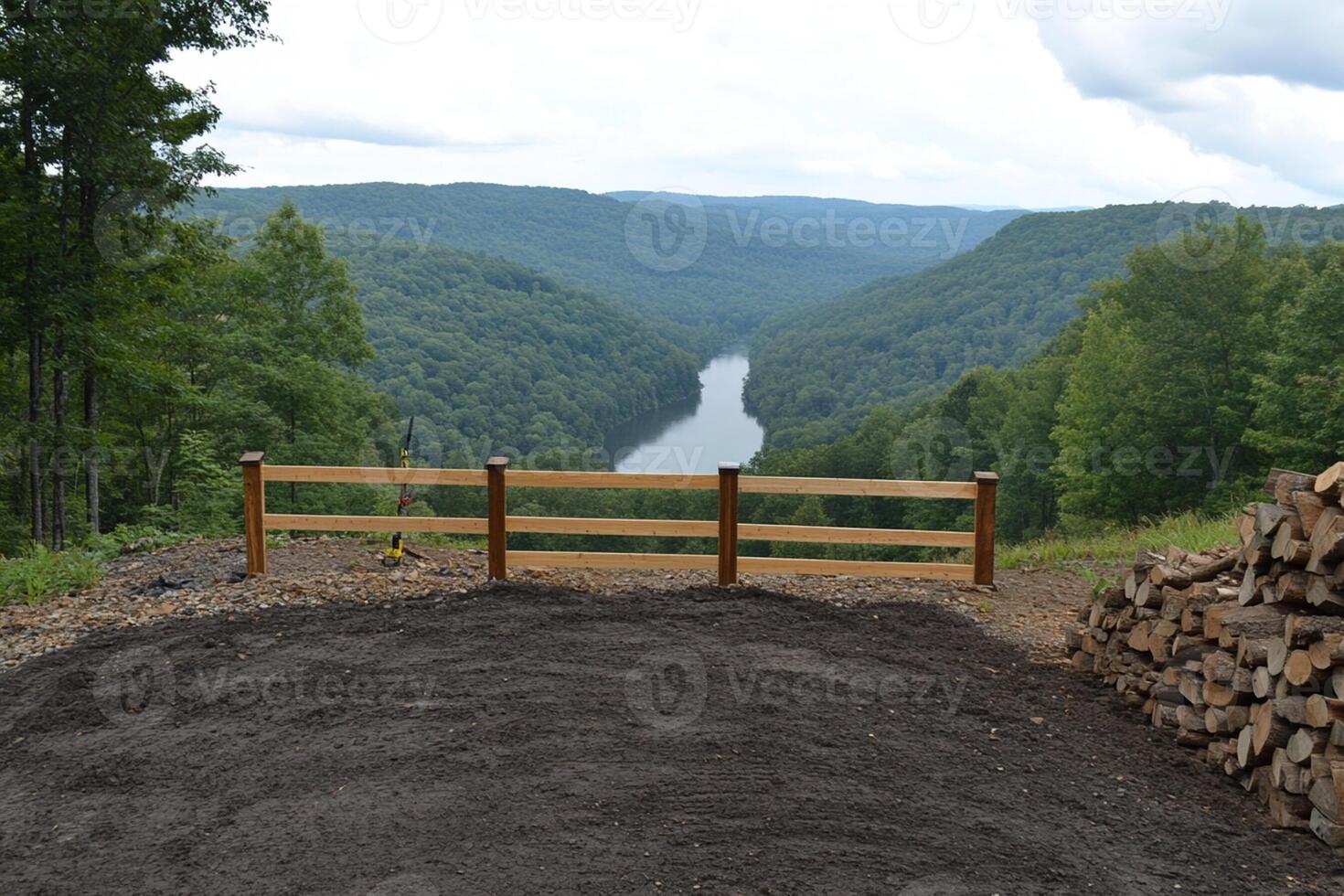 A wooden fence with a wooden gate in front of a river photo