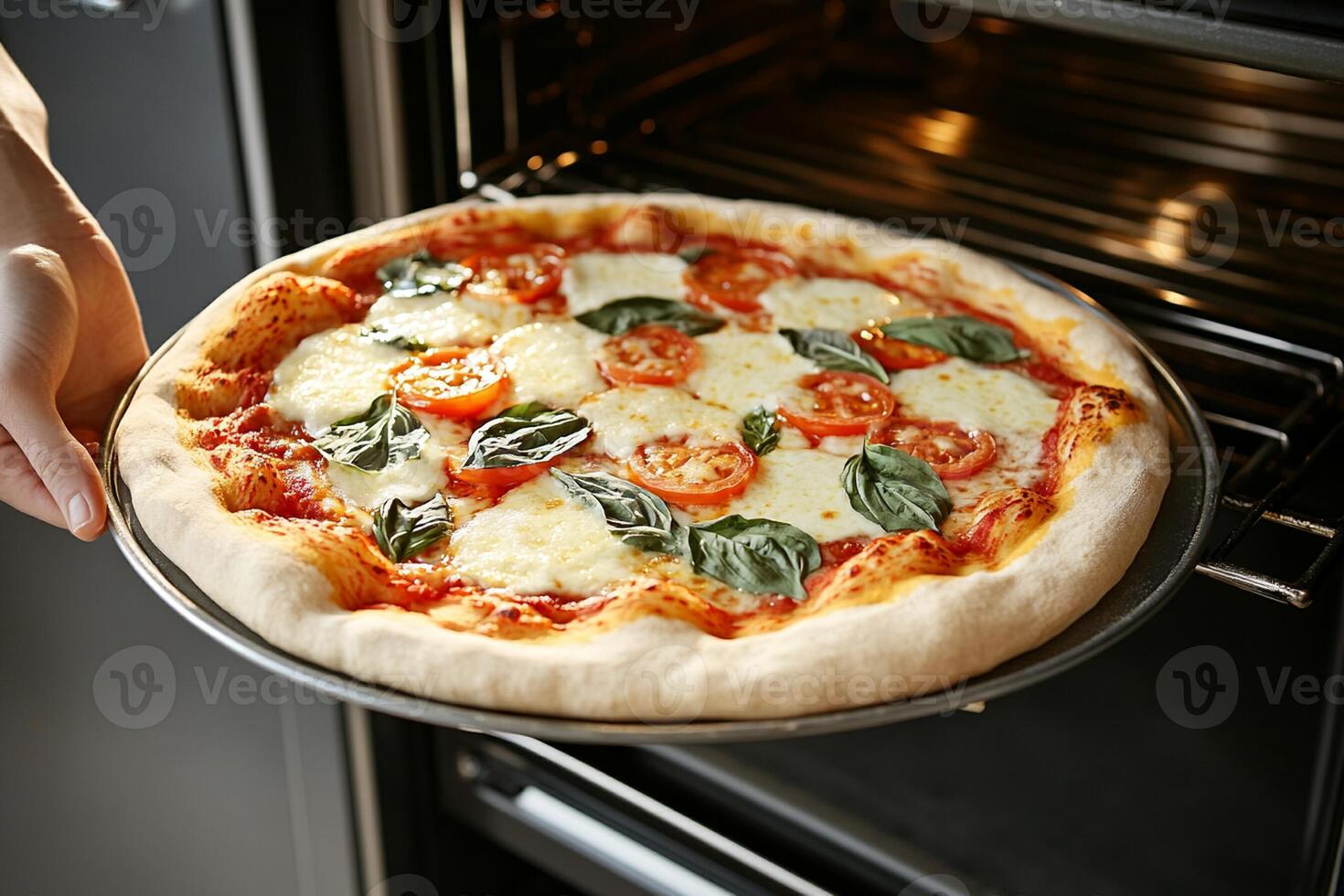 A person is holding a pizza out of an oven photo