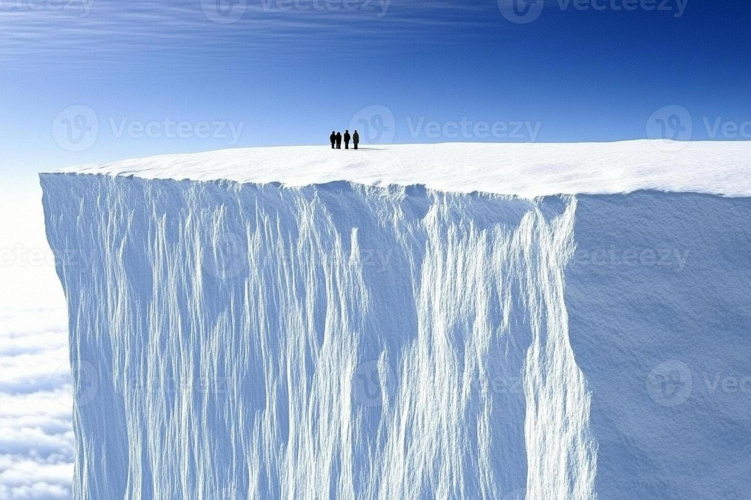 A group of people standing on top of a large ice cliff photo