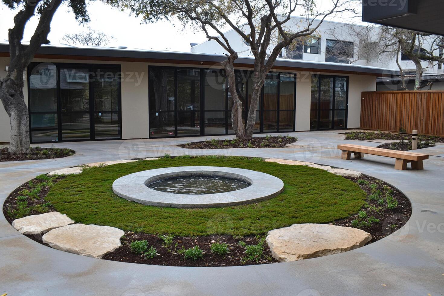A circular garden with a stone bench and a water feature photo