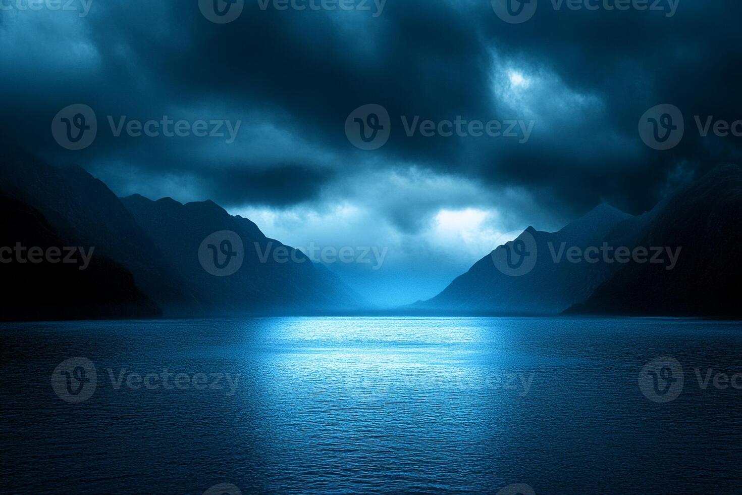 A dark blue lake with mountains in the background photo