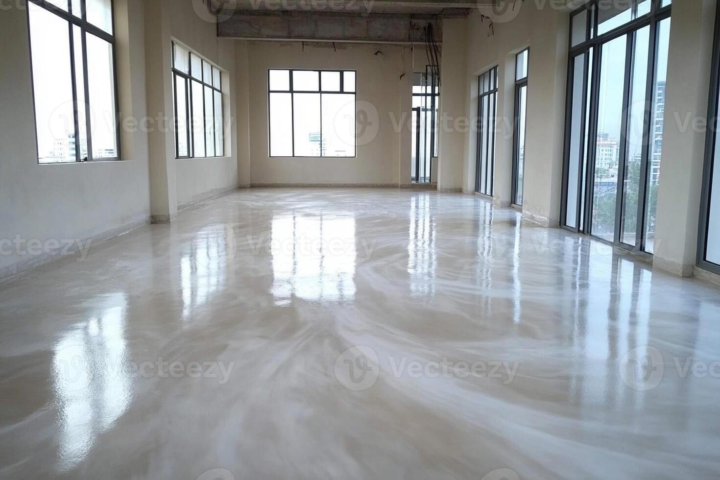 A large room with white flooring and windows photo