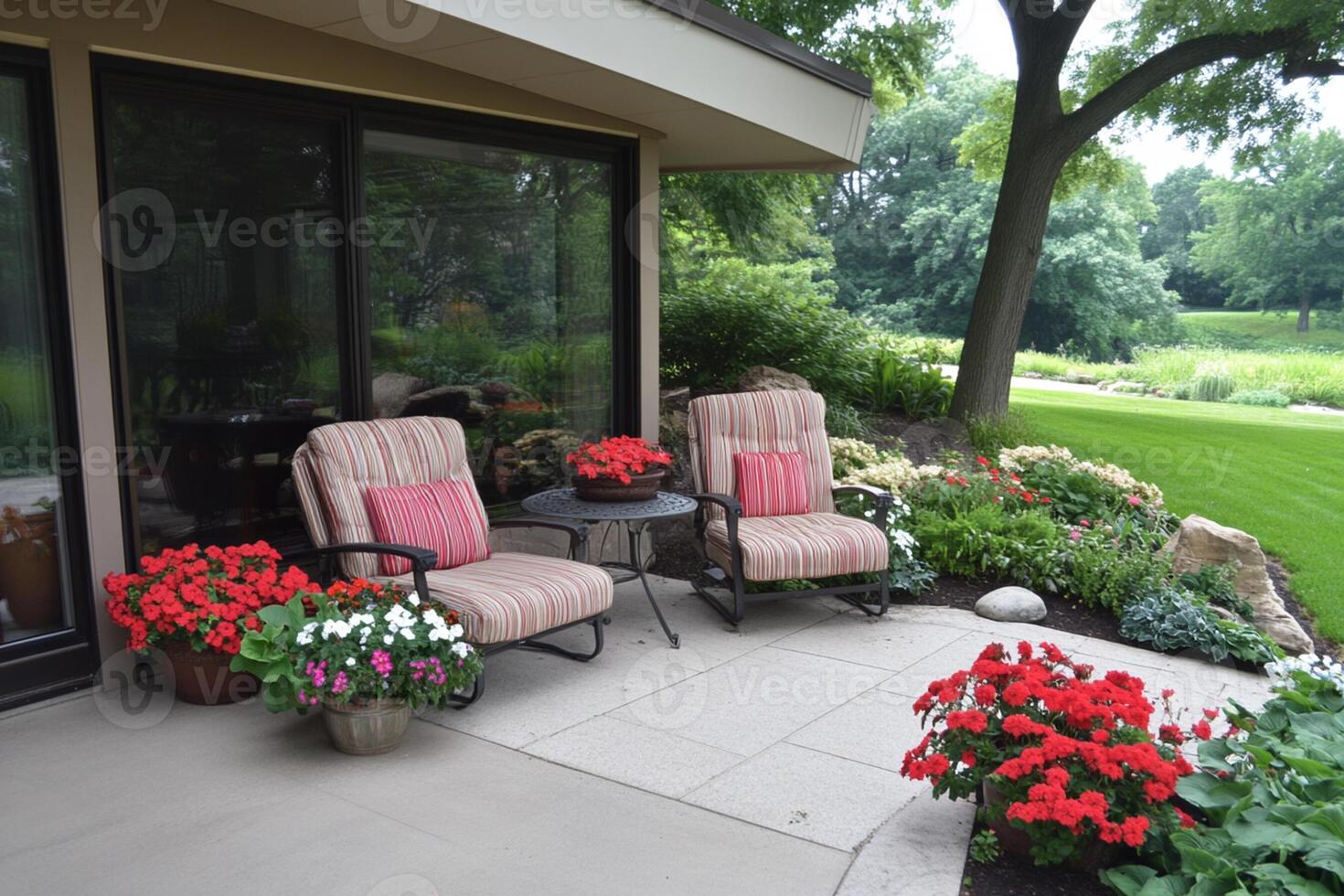 A patio with chairs and flowers in front of a house photo