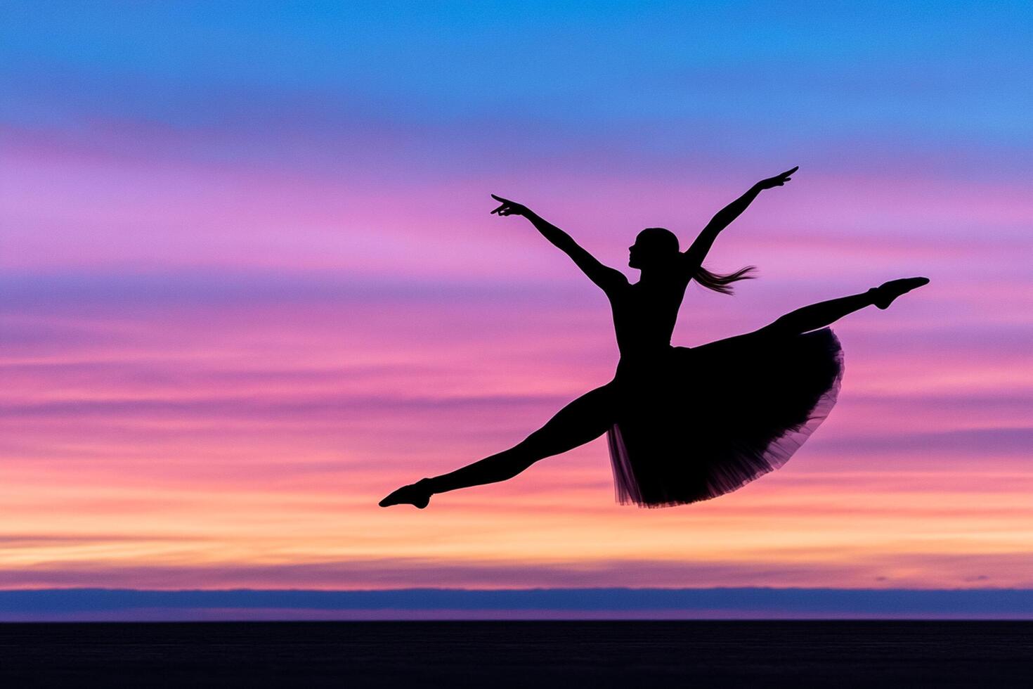 A woman in a tutu jumps in the air at sunset photo