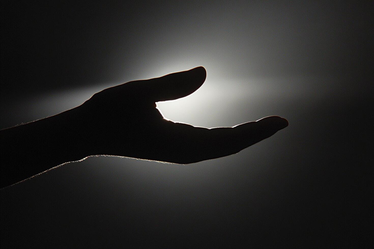 A person's hand is reaching out to the light photo