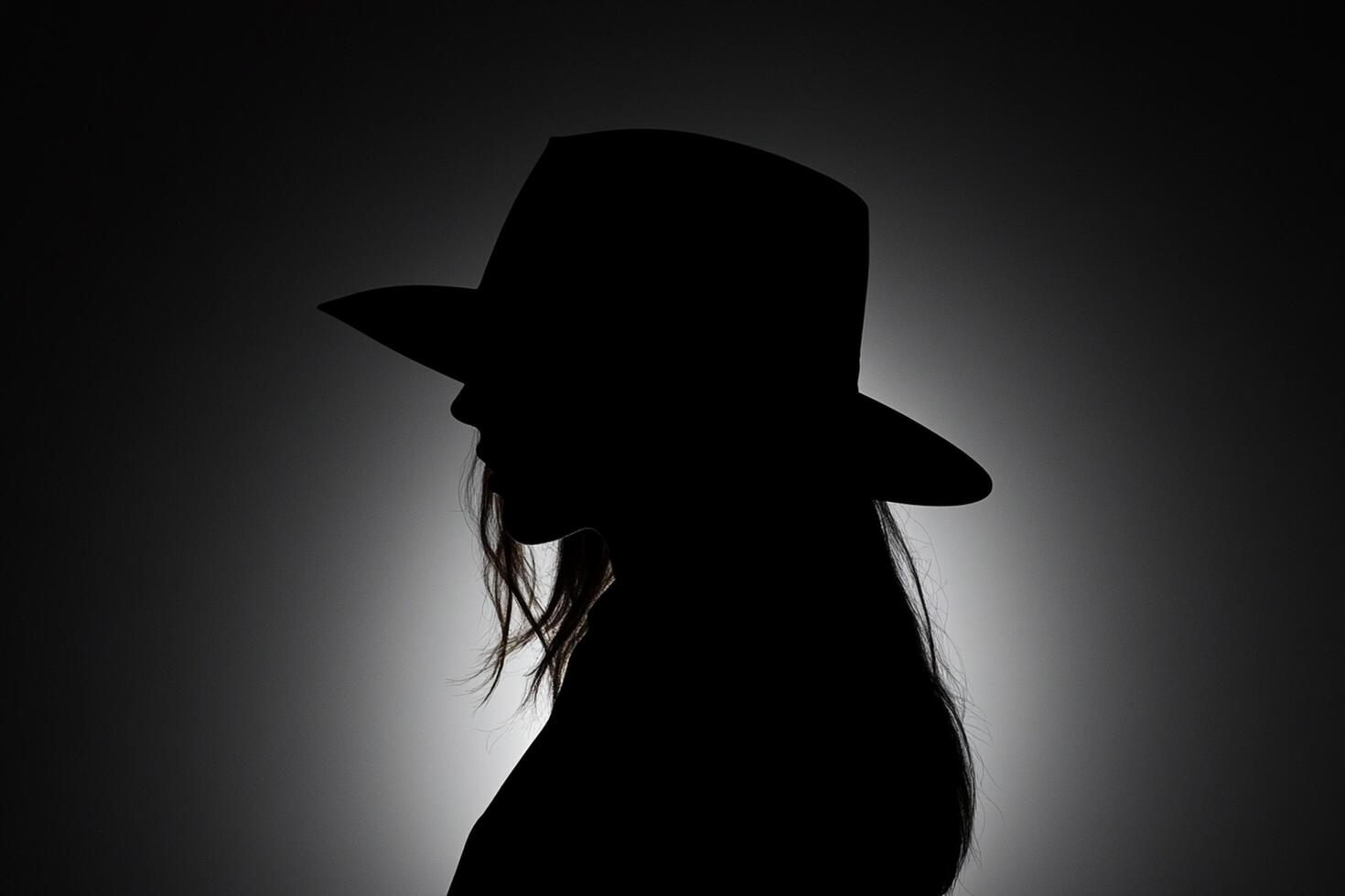 A silhouette of a woman in a hat photo