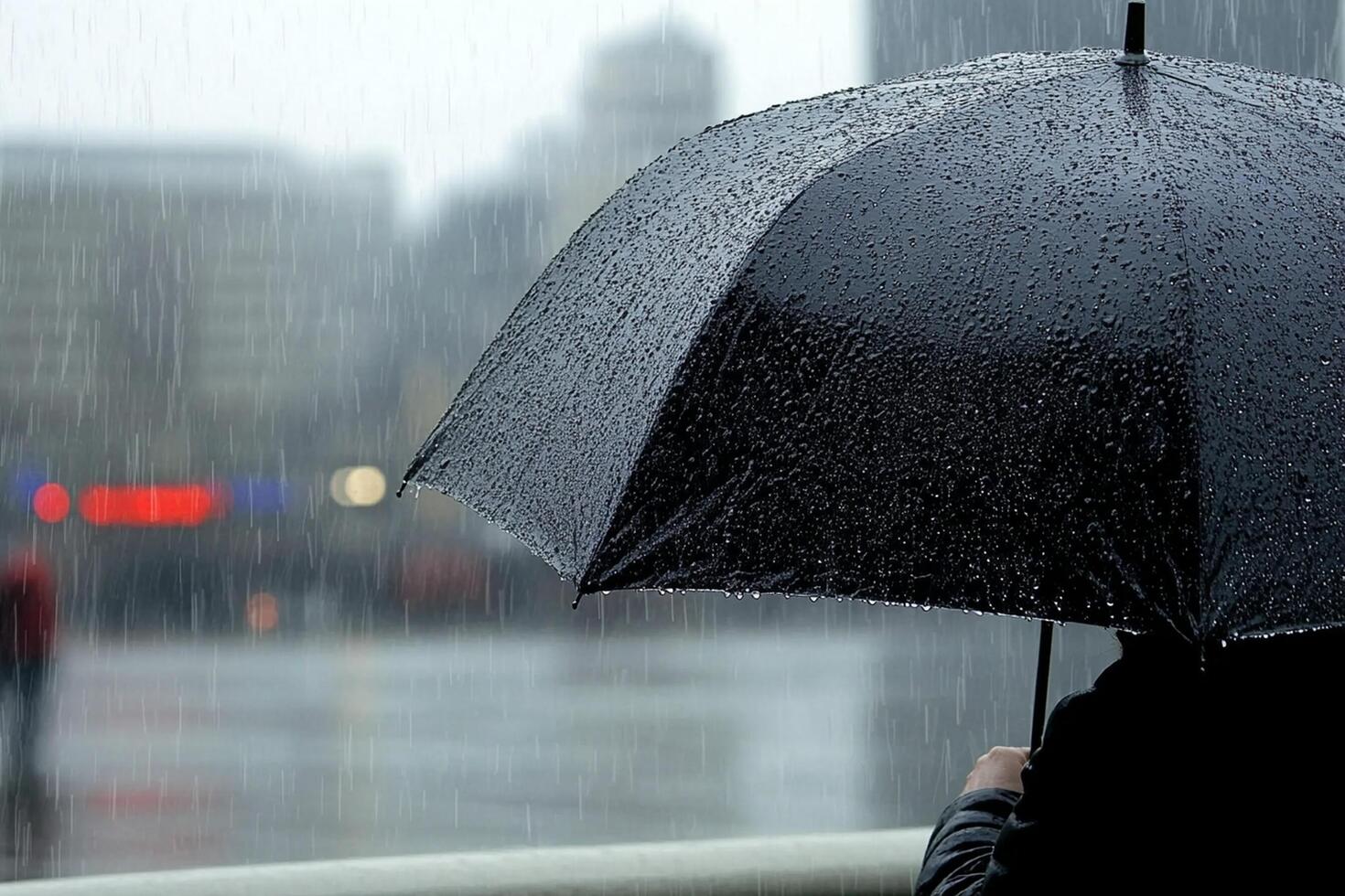 A person holding an umbrella in the rain photo