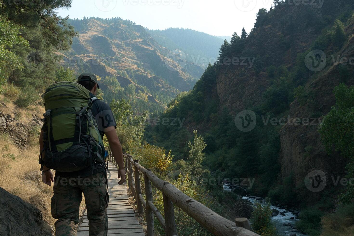 A man with a backpack walking on a wooden bridge photo