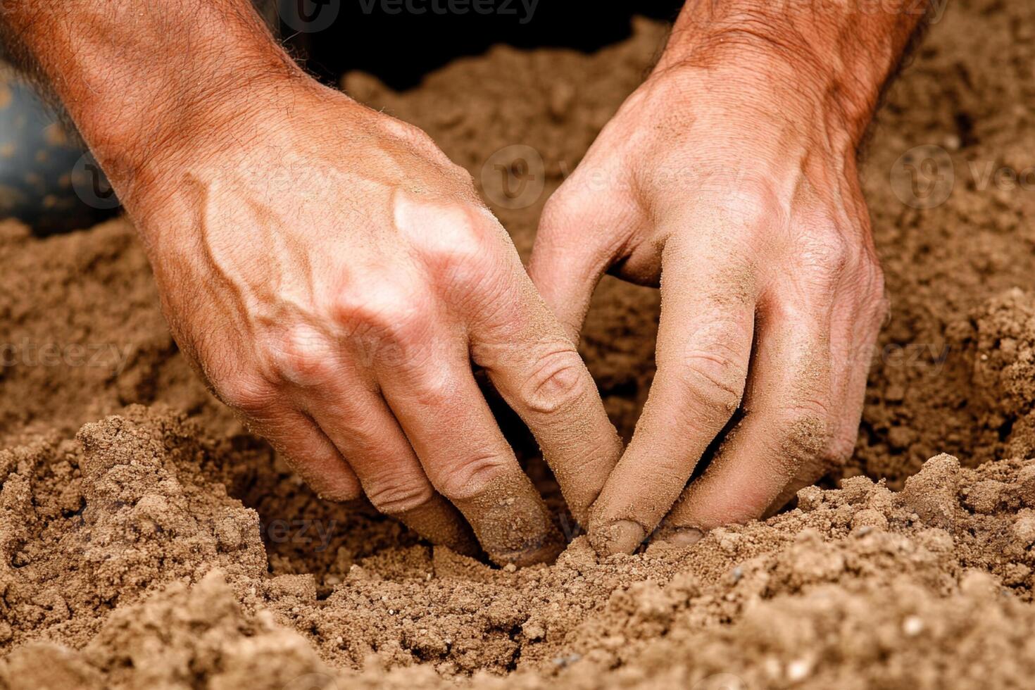 A man is digging into the ground with his hands photo