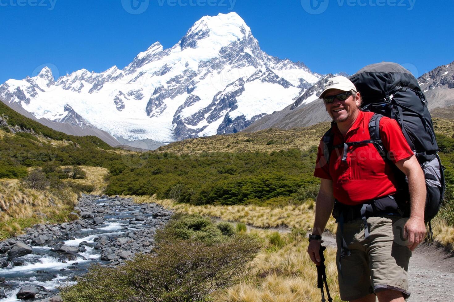 A man with a backpack and hiking poles standing in front of a mountain photo