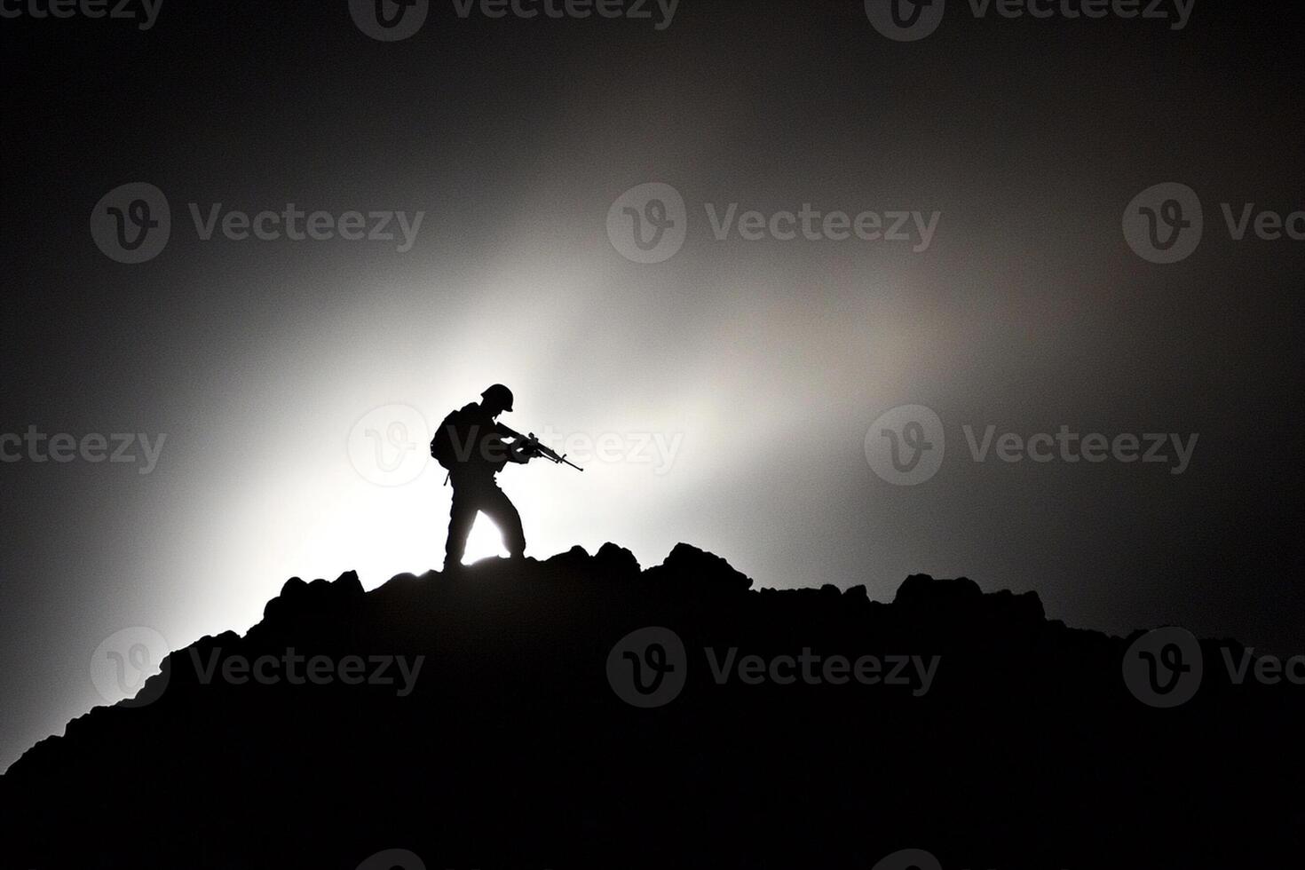 A silhouette of a man standing on top of a mountain photo