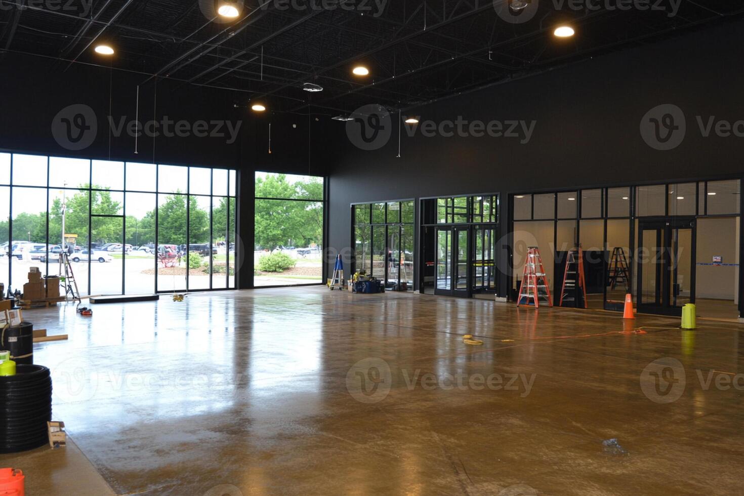 A large room with concrete floors and windows photo