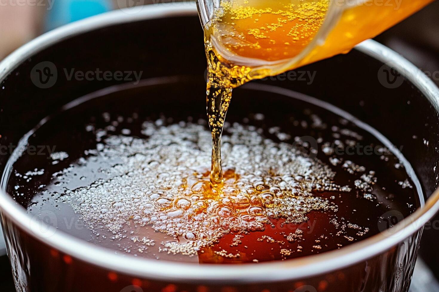 A person pouring syrup into a pot of syrup photo