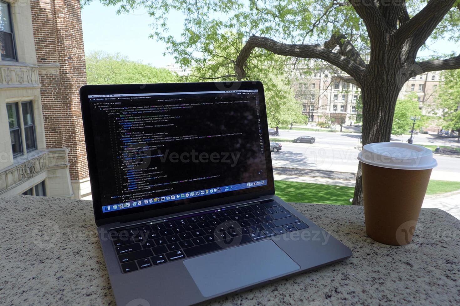A laptop computer and a cup of coffee on a ledge photo