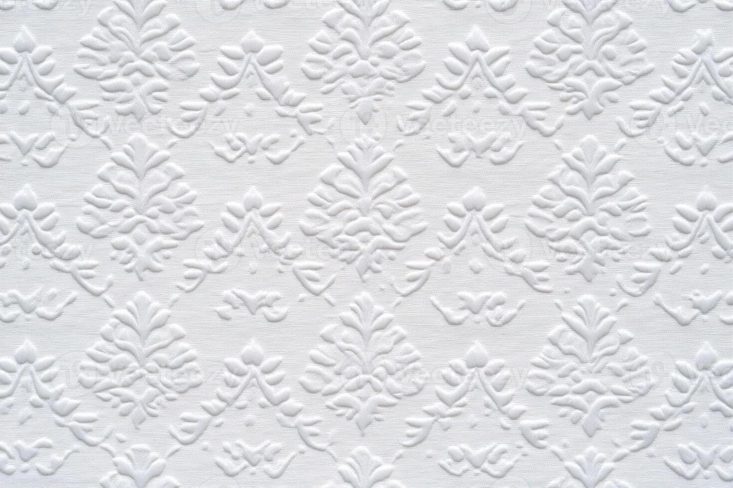 A white wall with a pattern of leaves photo