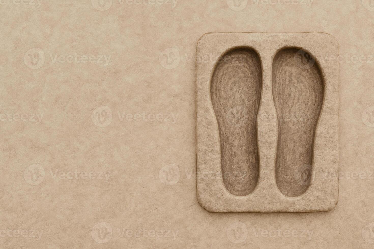 An artistic and minimalist composition reveals a textured, earth-toned foot impression on a rectangular tablet. photo