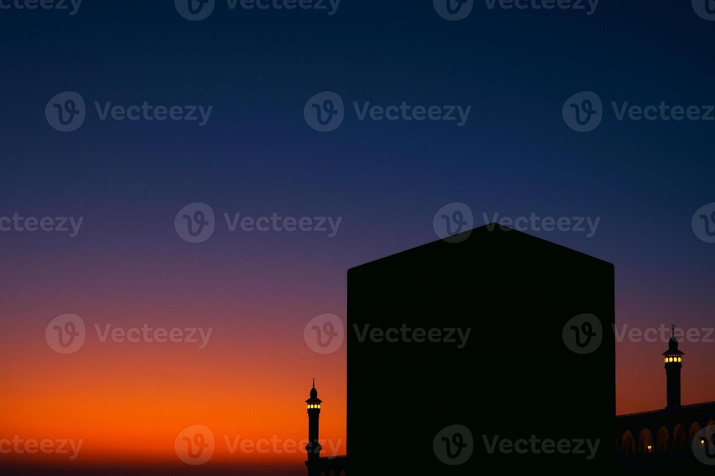 a silhouette of a kaaba building at sunset photo