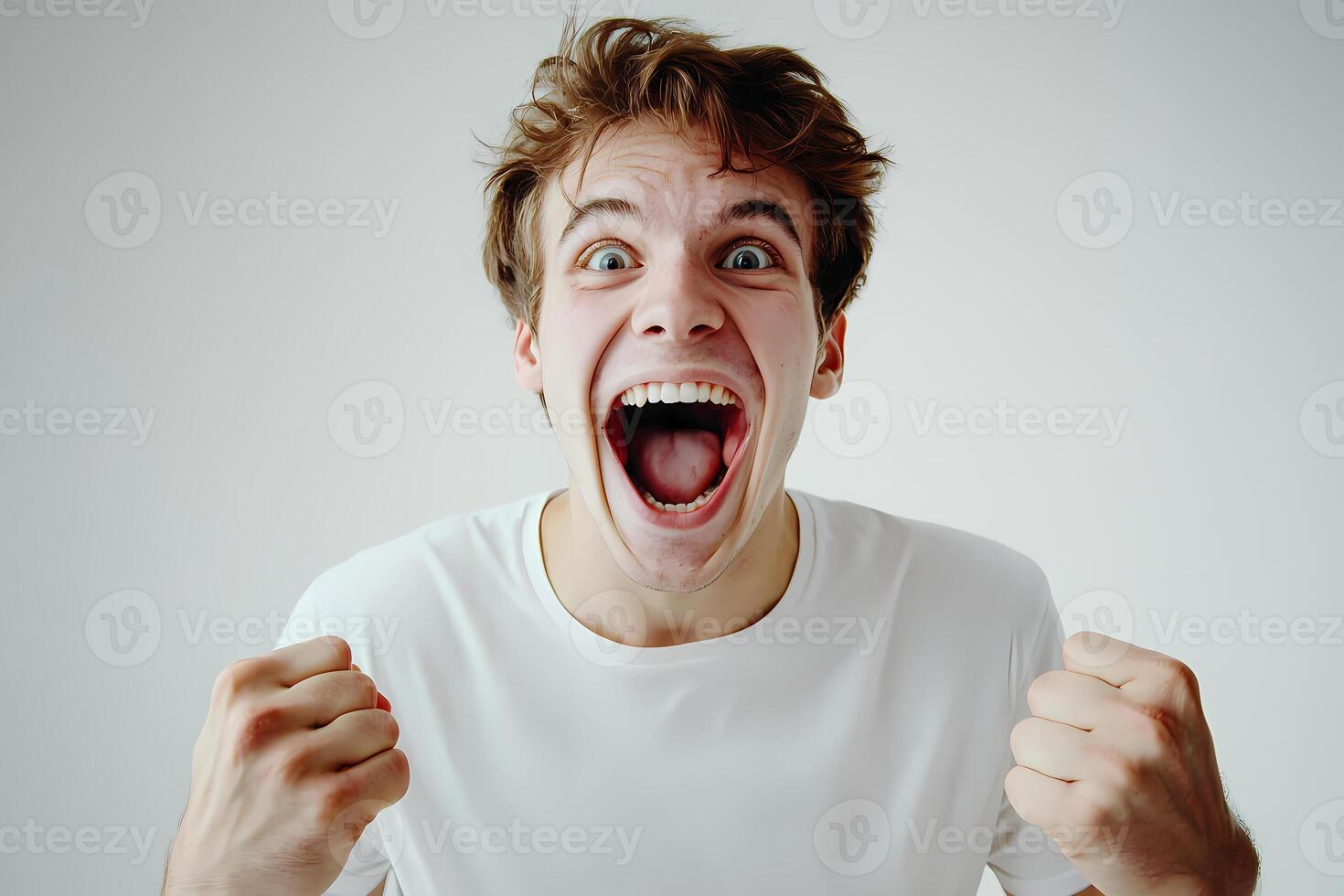 Excited young man shouting and raising fists in triumph photo