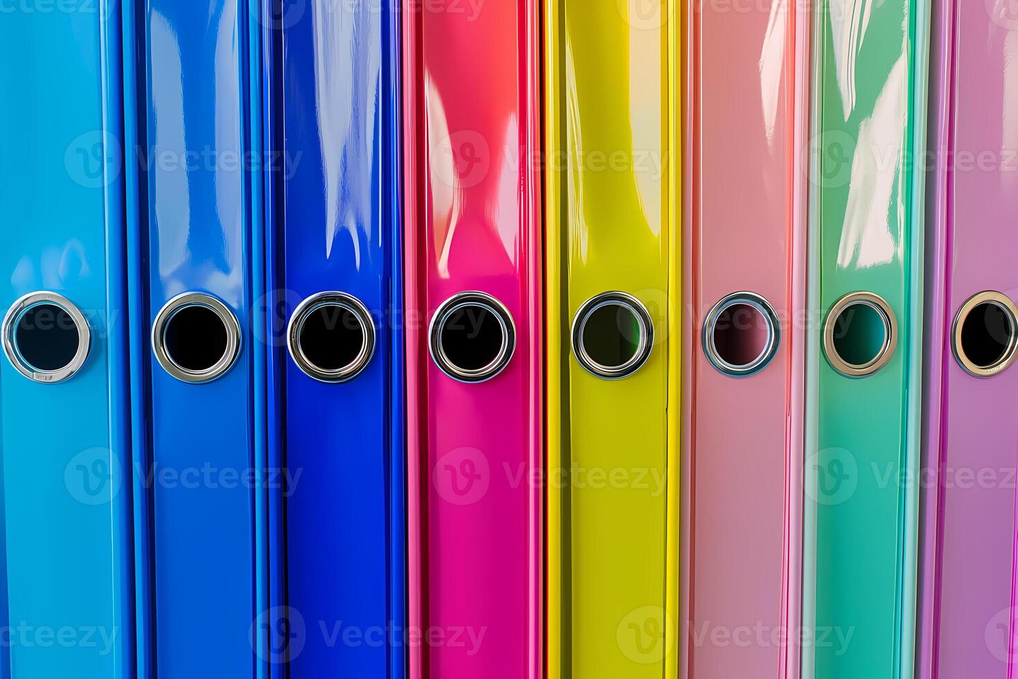 Colorful ring binders standing in a row creating a vibrant rainbow pattern photo