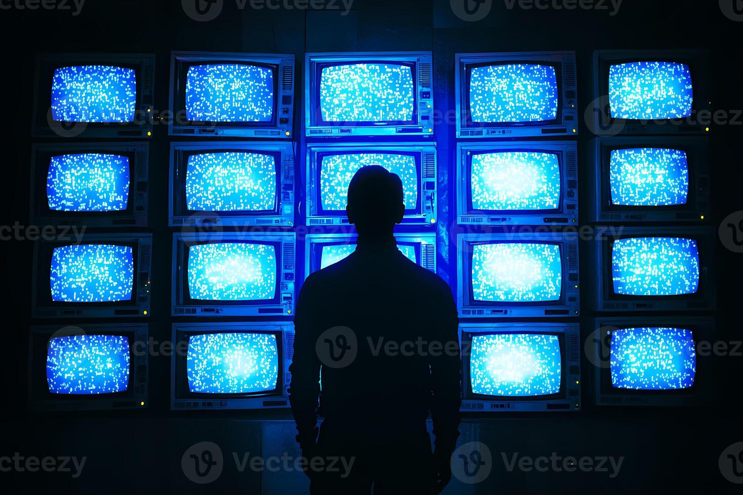 Technician observing wall of televisions displaying blue static noise photo