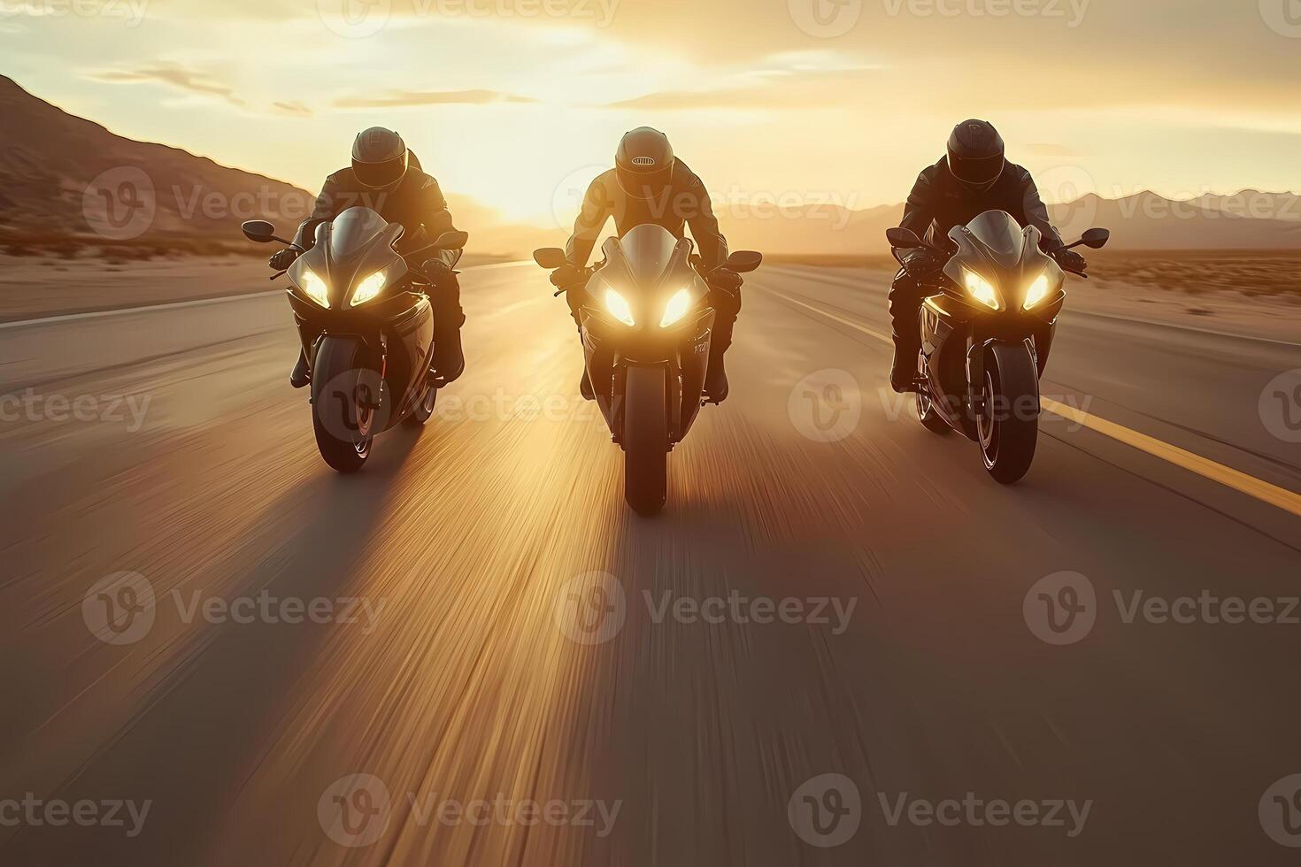 Three motorcyclists riding sport motorcycles on desert highway at sunset photo