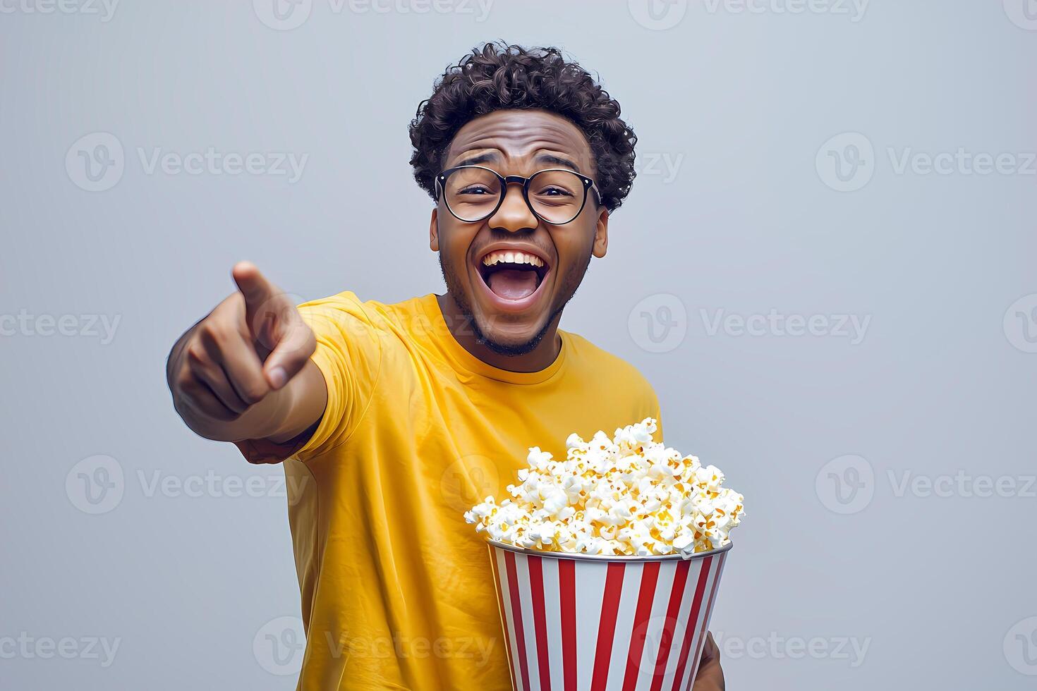 Excited man enjoying movie with popcorn and pointing finger photo