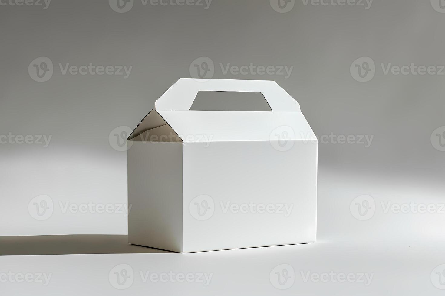 White cardboard box with handle on gray background photo