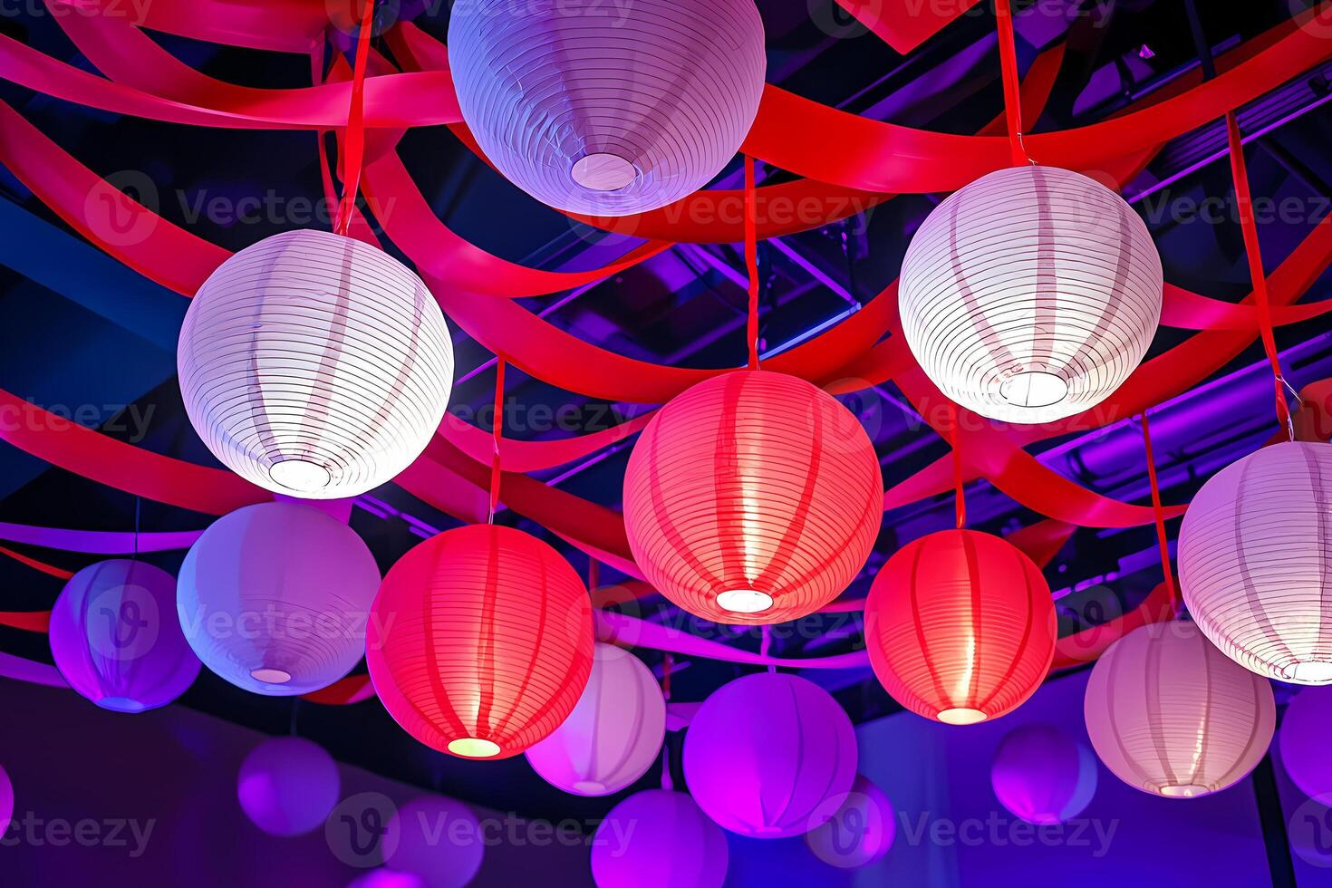 Colorful paper lanterns hanging from red ribbons creating a festive atmosphere photo
