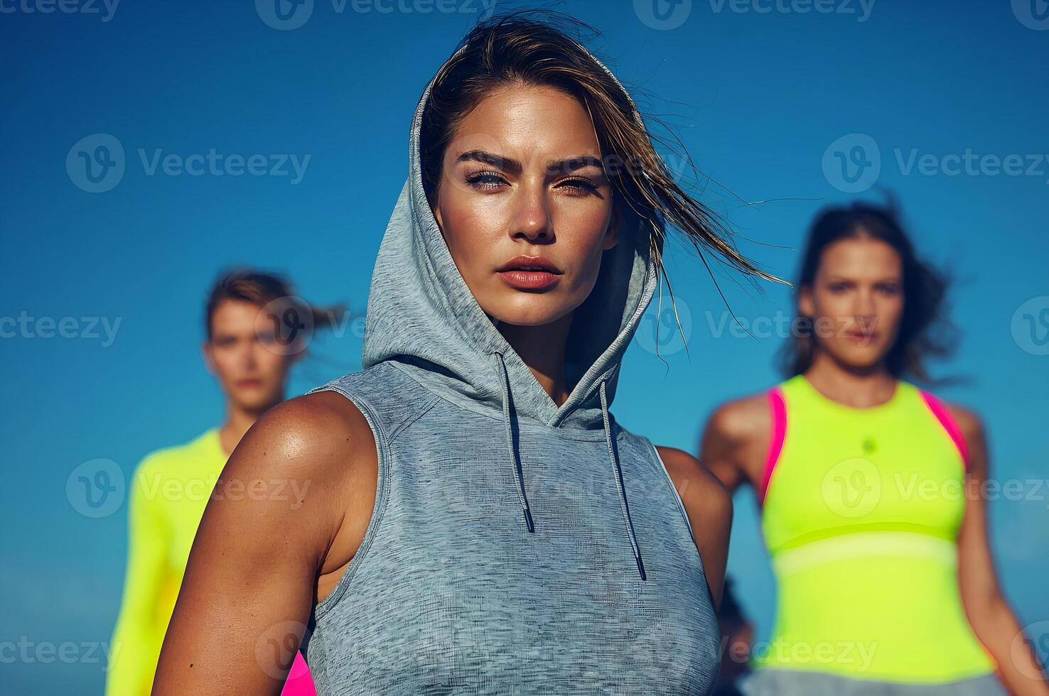 Sporty women wearing sleeveless hoodies and tank tops are running outdoors photo