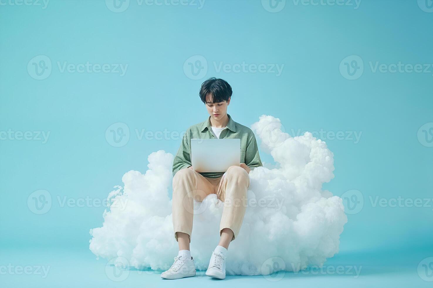 Young man working on laptop sitting on cloud computing concept photo
