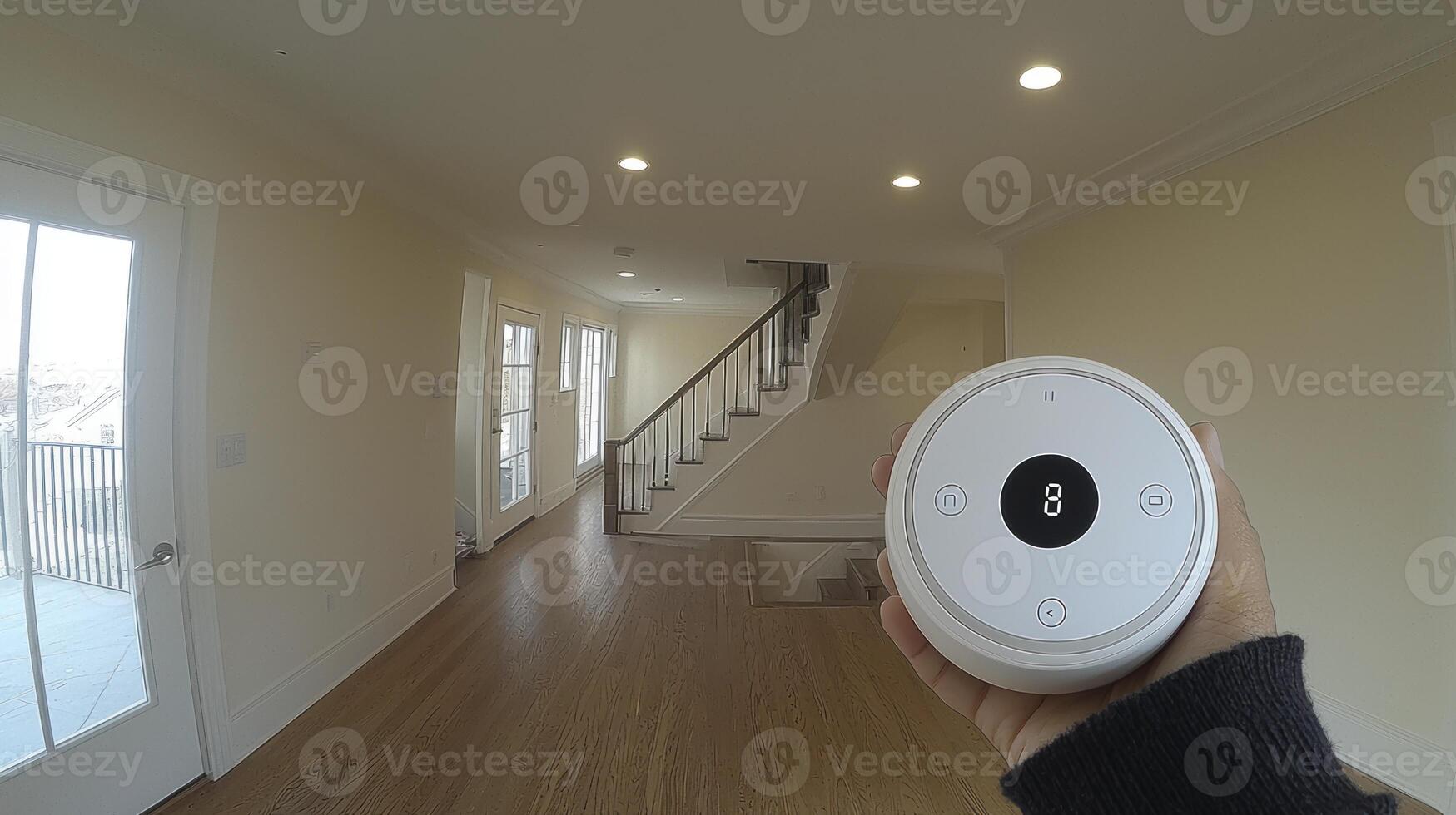 A person holding a remote control in a hallway photo