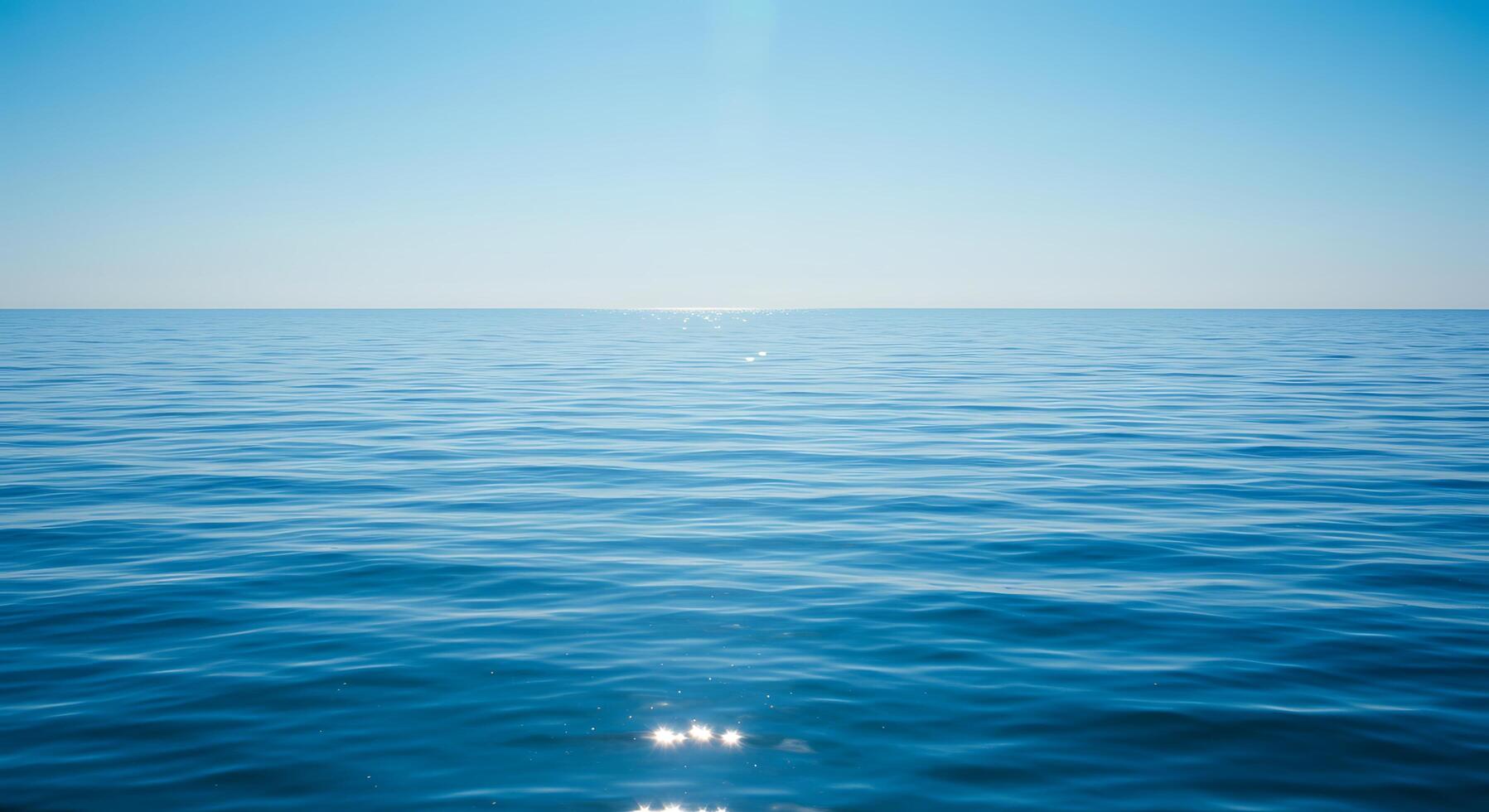 A view of the ocean with a bright sun shining over it photo