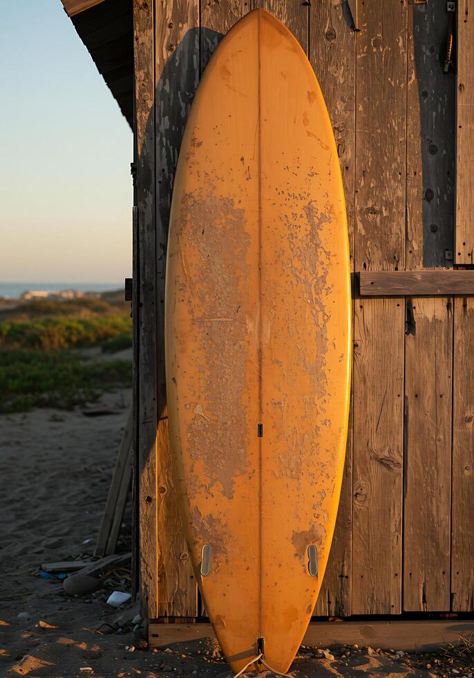 A surfboard leaning against a wooden building photo