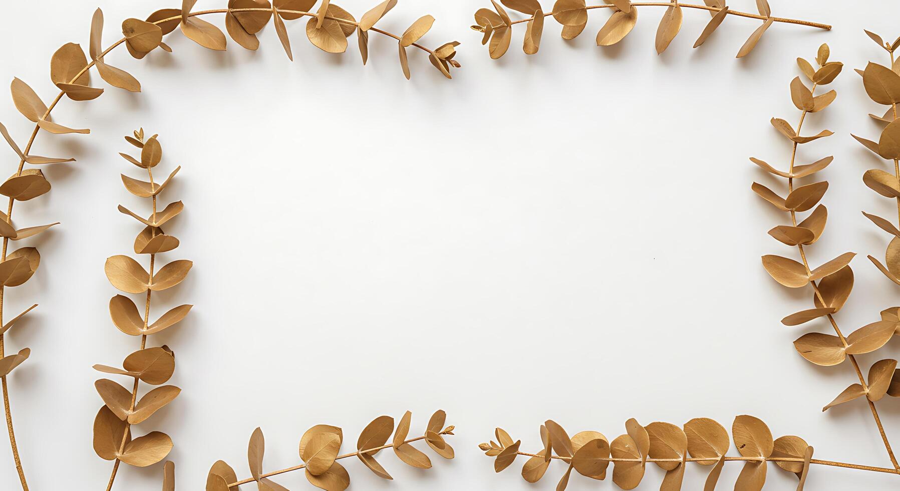 Golden leaves arranged in a square frame on a white surface photo