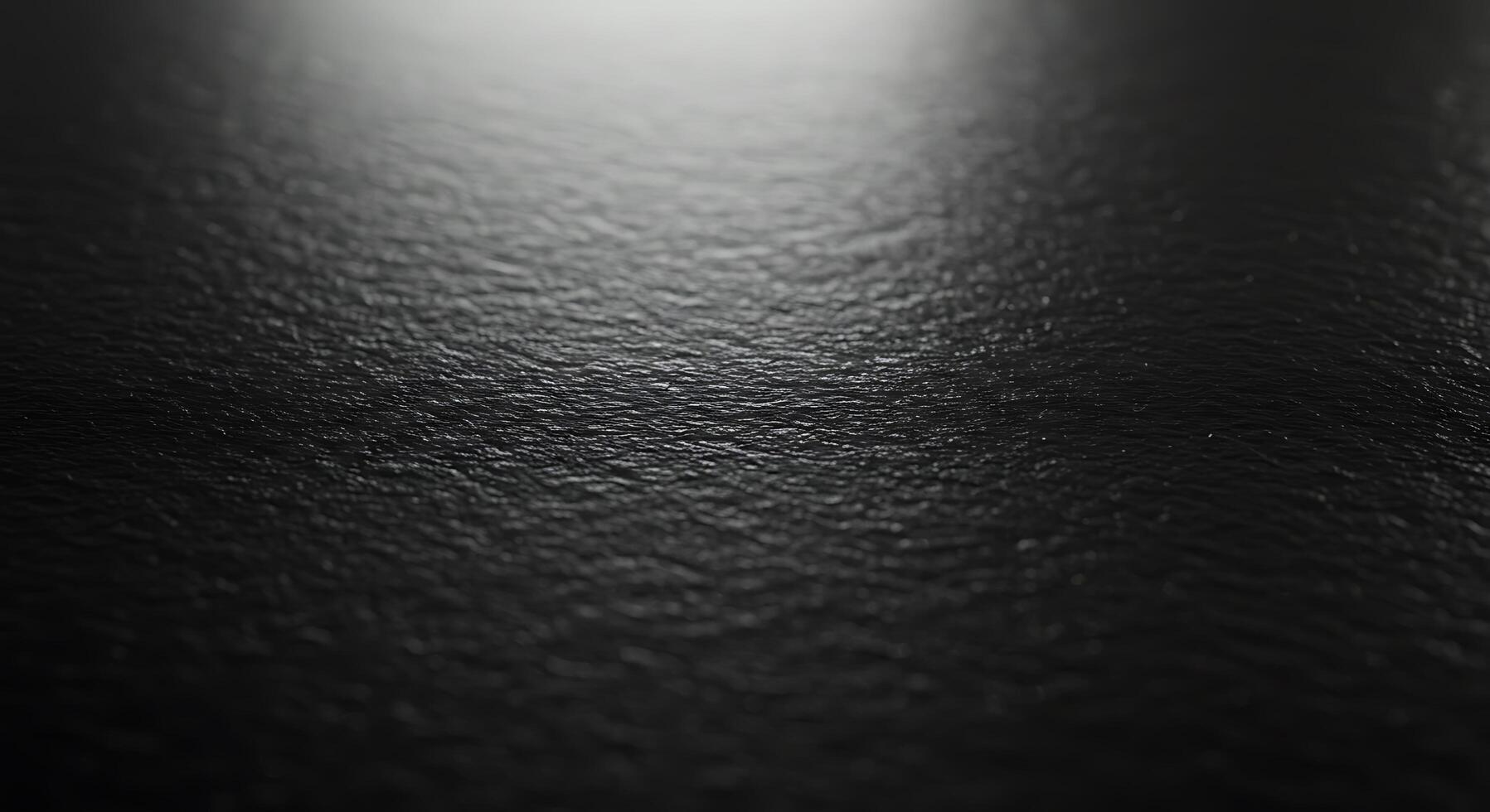 A black surface with a light shining on it photo