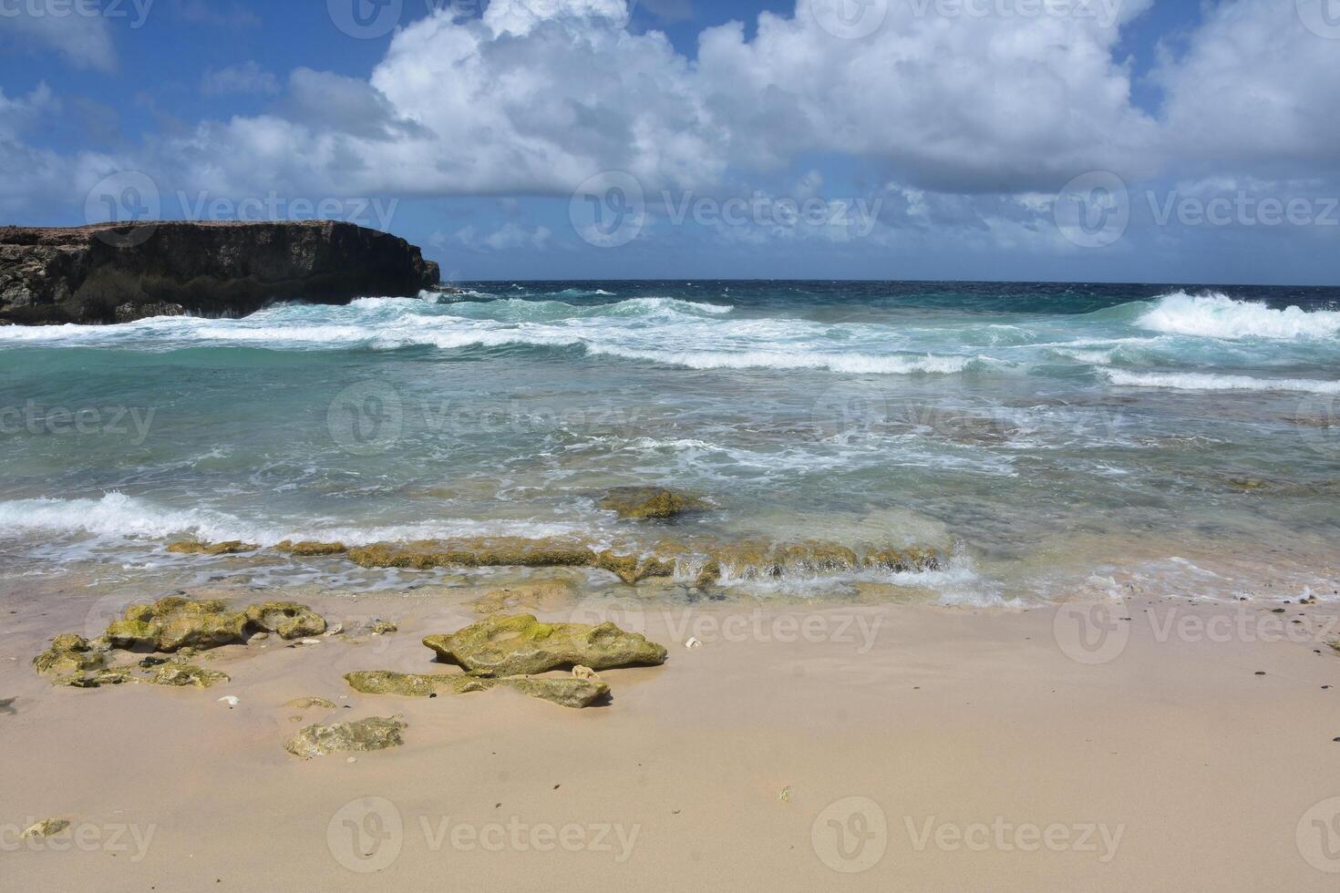 Waves Rolling Ashore Under Puffy White Clouds photo