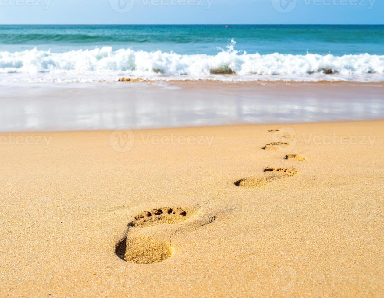 Footprints leading toward a tranquil ocean shore. photo