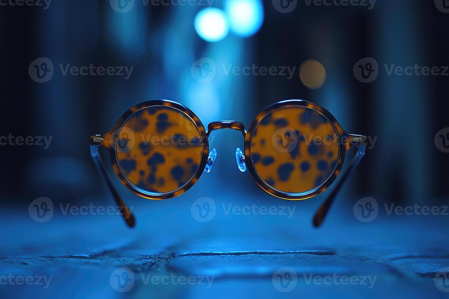 Round eyeglasses with tortoiseshell pattern are floating in mid air photo