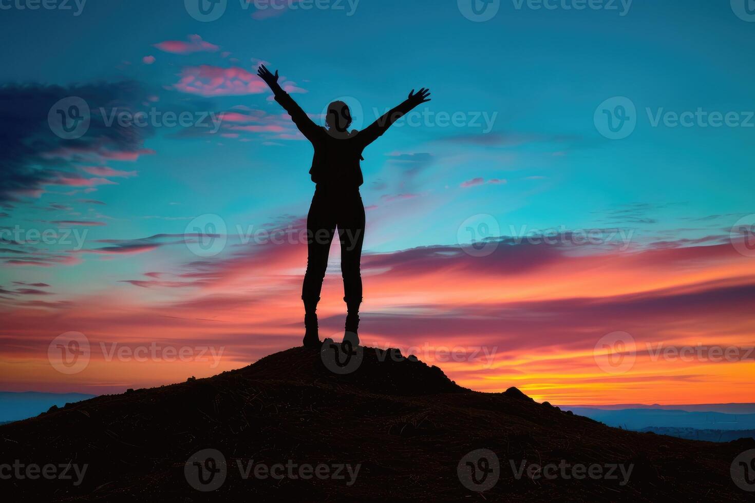 Silhouette of a person celebrating on a mountaintop at sunrise. photo