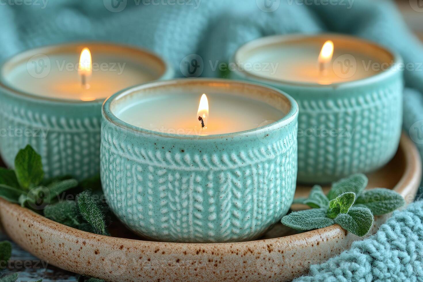 Three burning candles are placed on a tray with decorative leaves photo