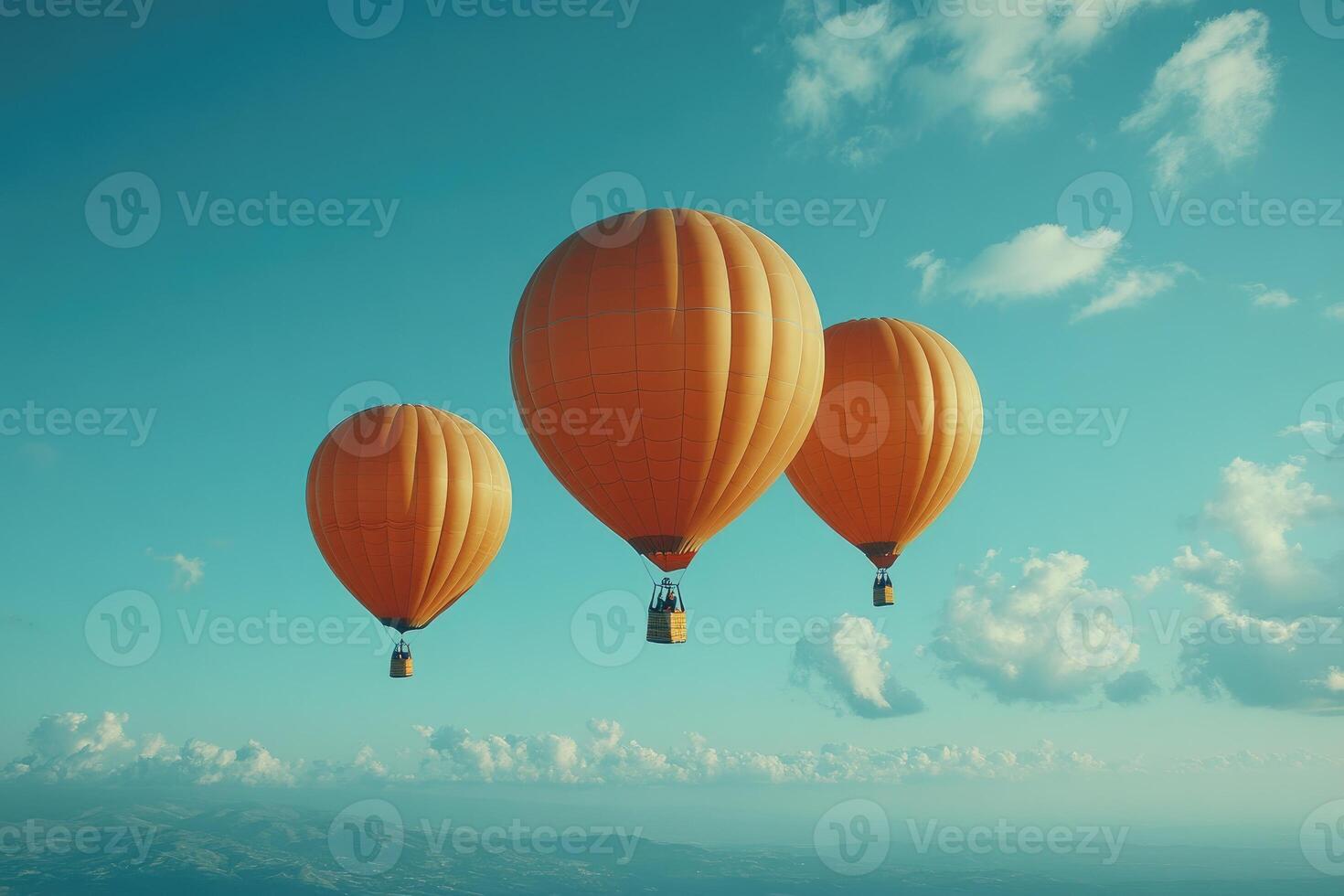 Three orange hot air balloons are floating in the bright blue sky photo