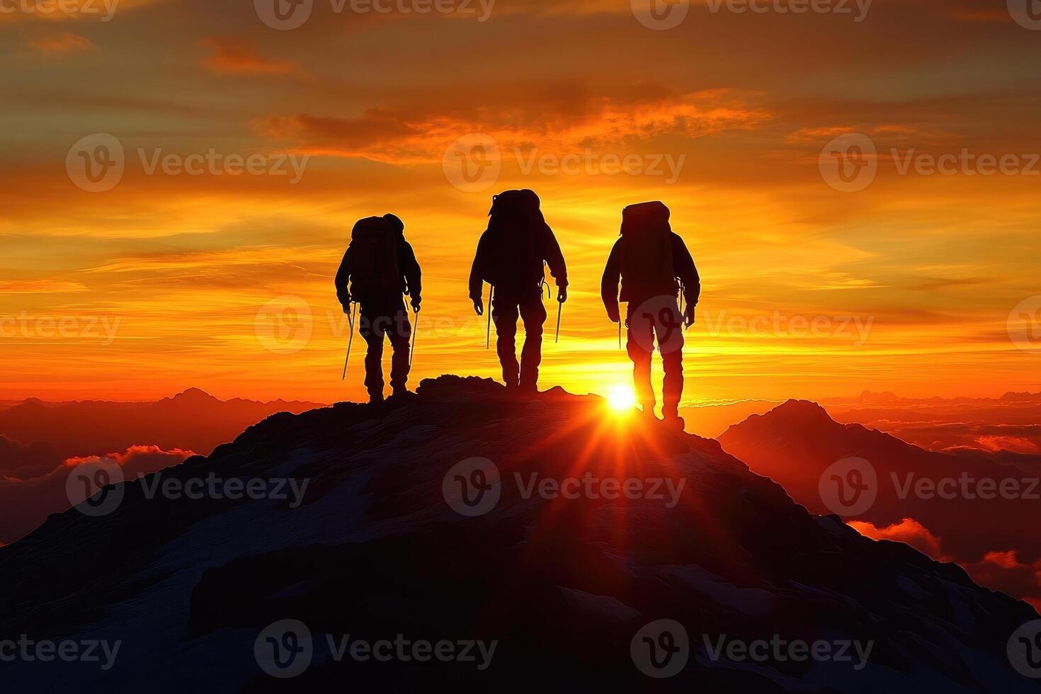 Three mountain climbers silhouette against a beautiful golden sunset sky photo