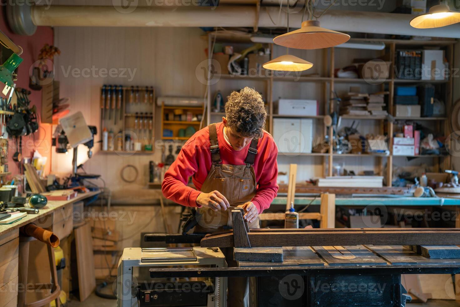Woodworker man carefully spread glue with spatula before attaching leather padding to wood surface photo