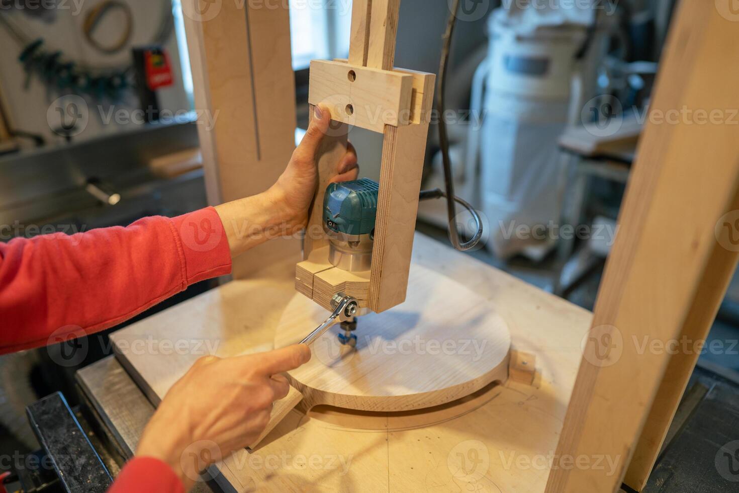 Artisan hands set up woodworking machine for vertical boring, adjustment of upscale drill press photo