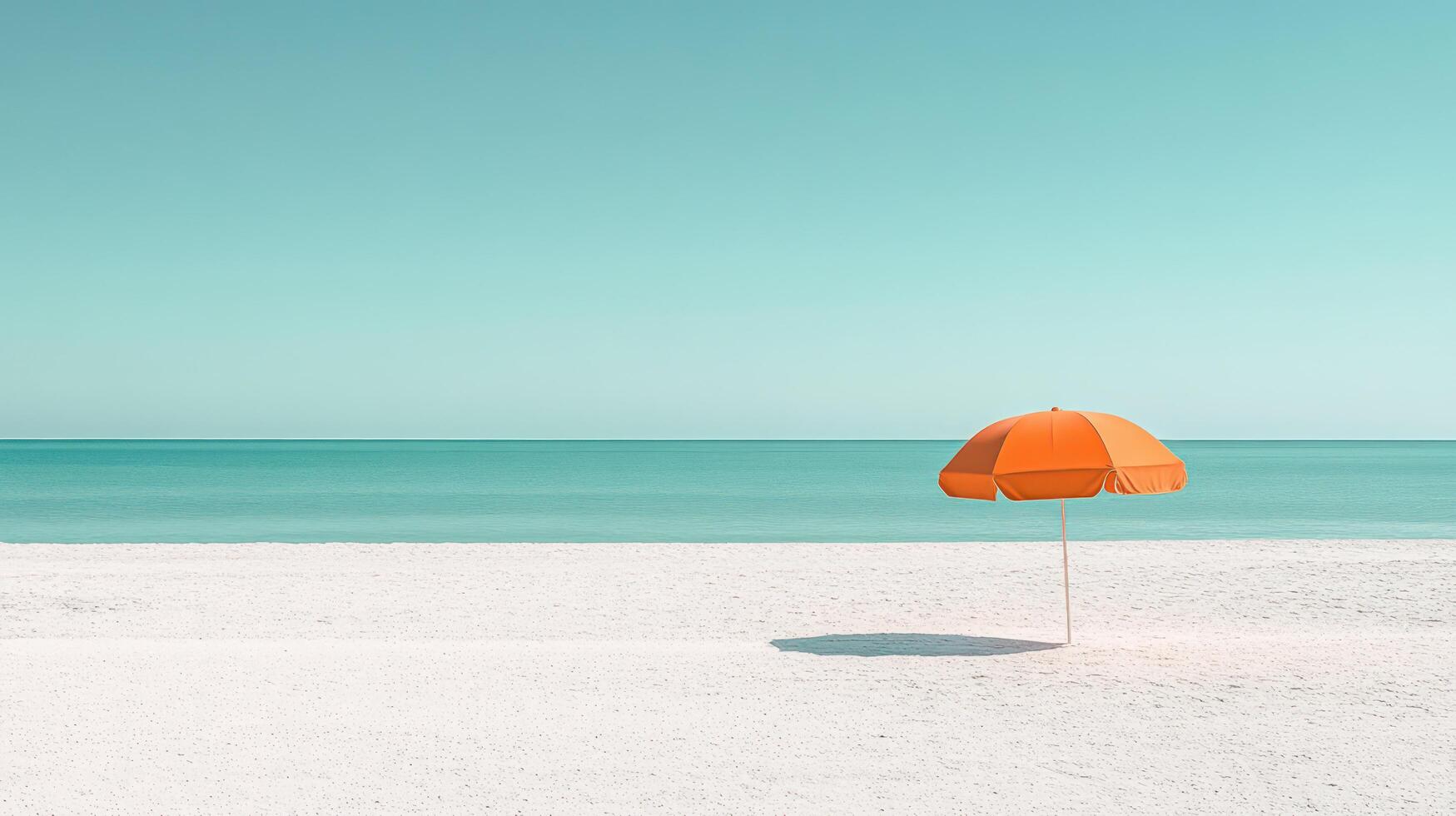 An orange umbrella on the beach with the ocean in the background photo