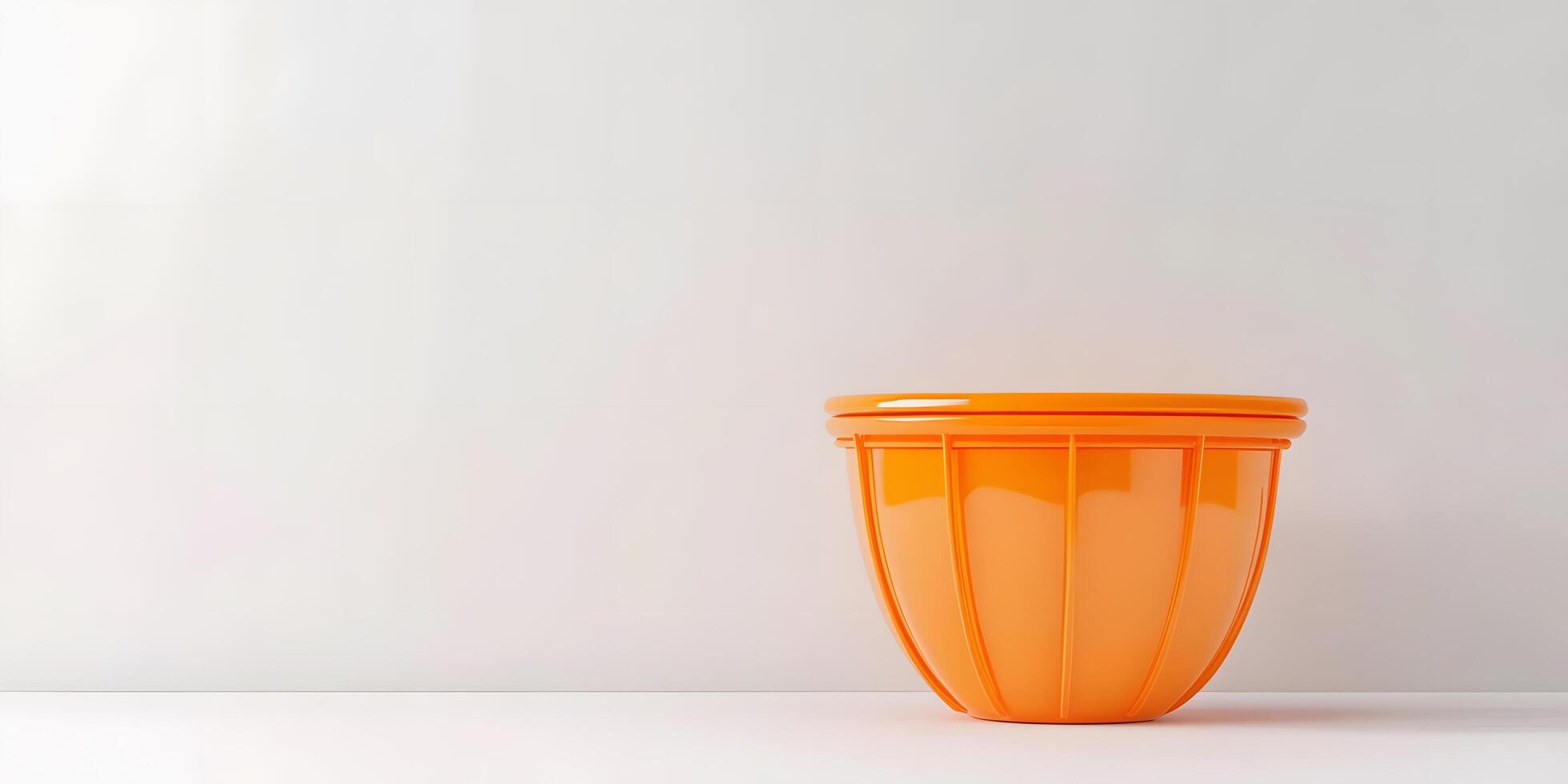 A bright orange cup sitting on a white surface photo