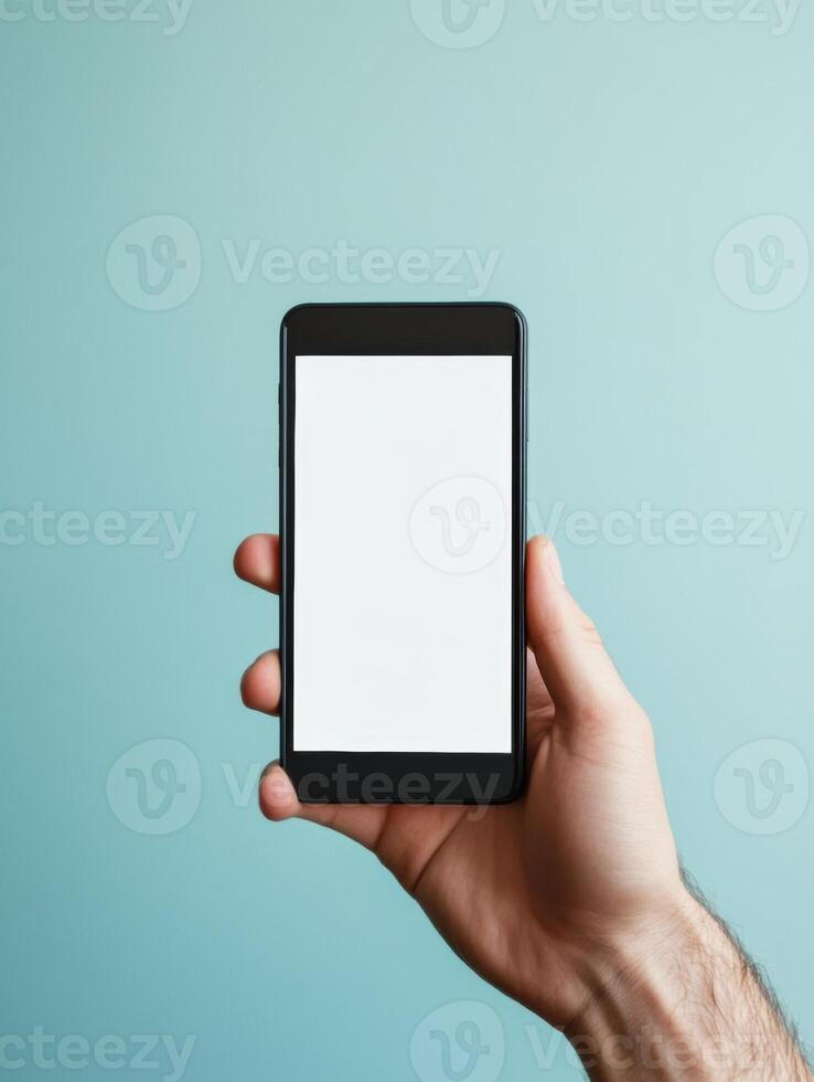 Close up of hand holding smartphone on blue background for technology design photo