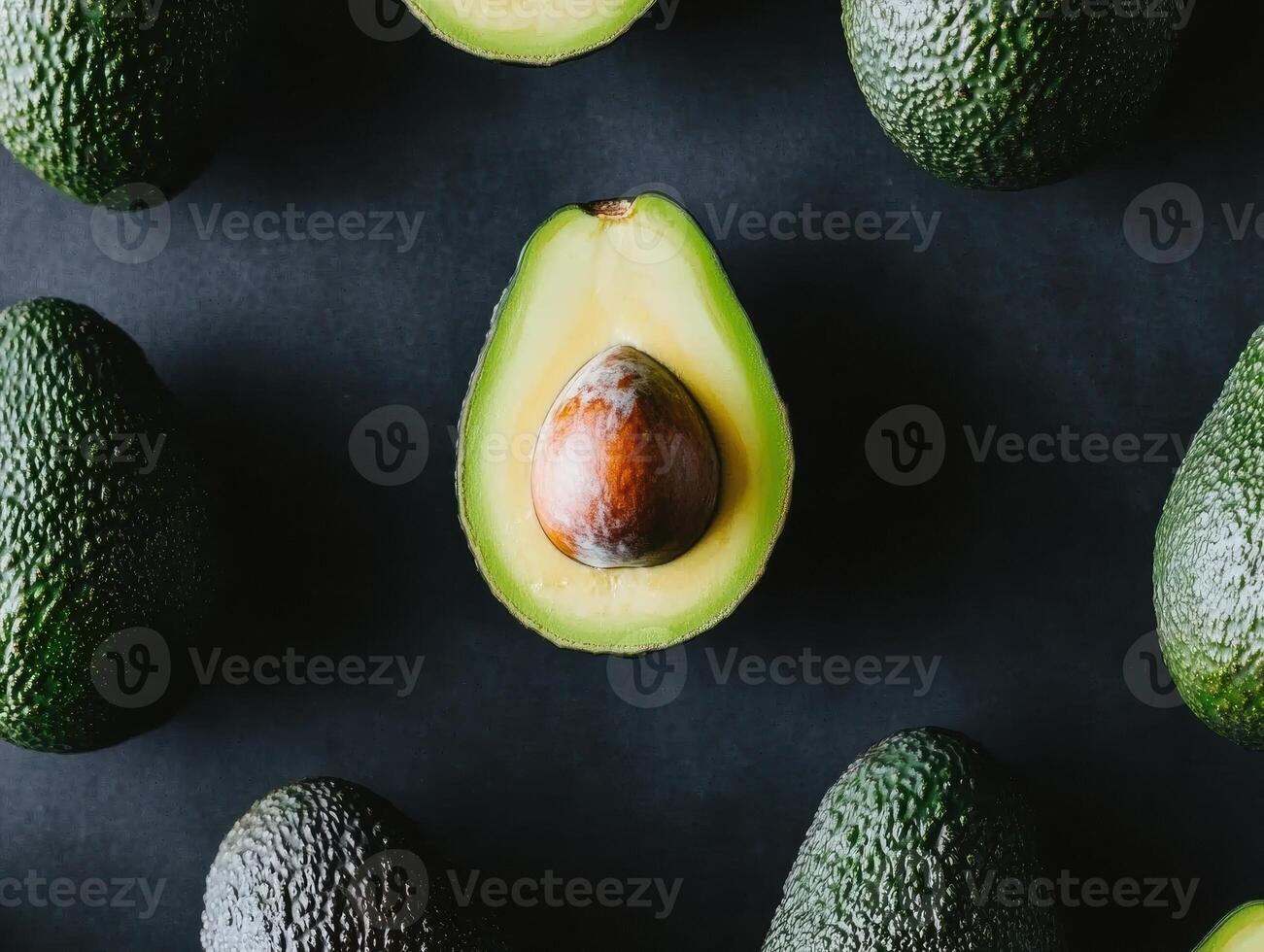 Fresh and healthy assorted avocados on dark background for culinary inspiration photo