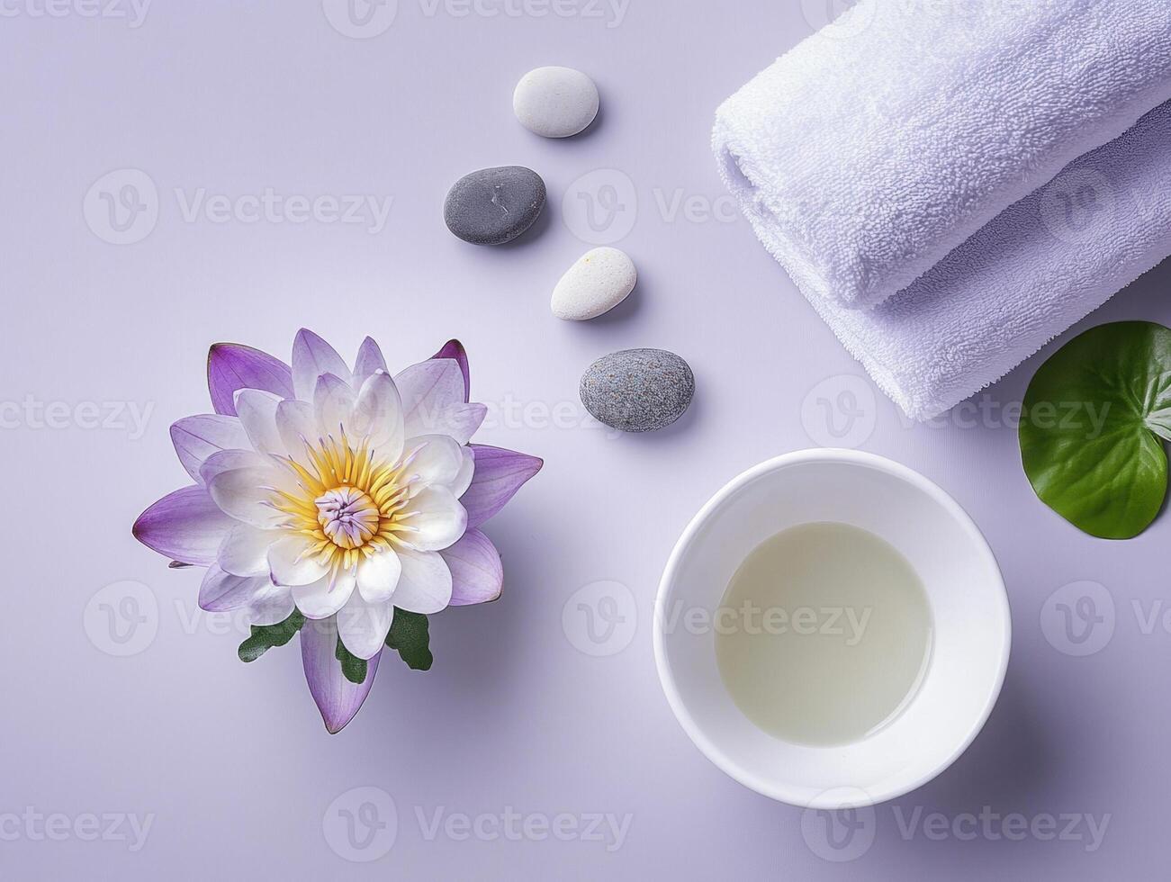 Peaceful spa setting with white ceramic bowl, essential oil, and lotus flower for relaxation and wellness photo