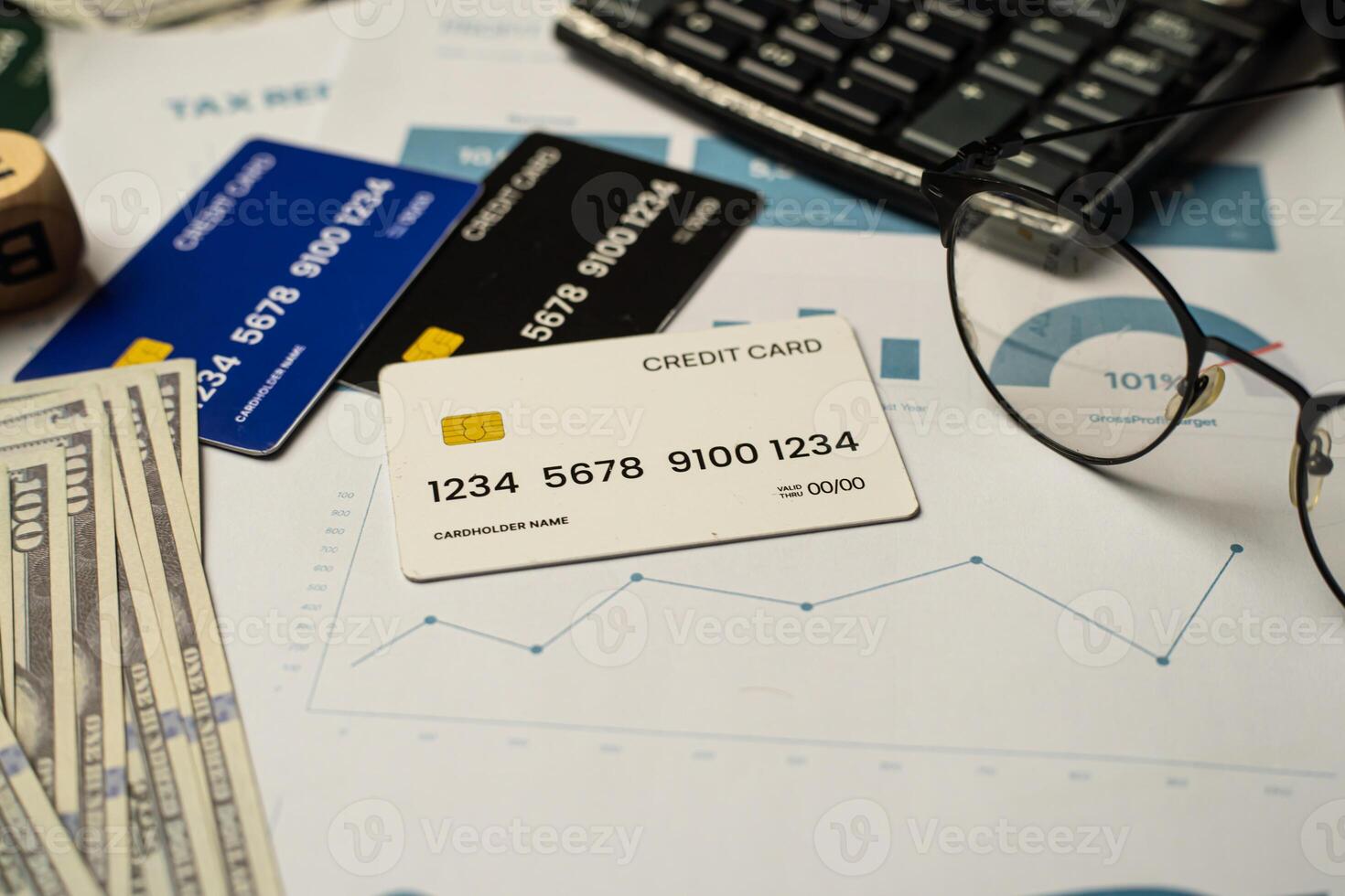 Top view of a realistic credit cards, hundred-dollar bills, performance charts, and a keyboard. The image evokes themes of financial literacy, digital payment systems, and economic analysis. photo